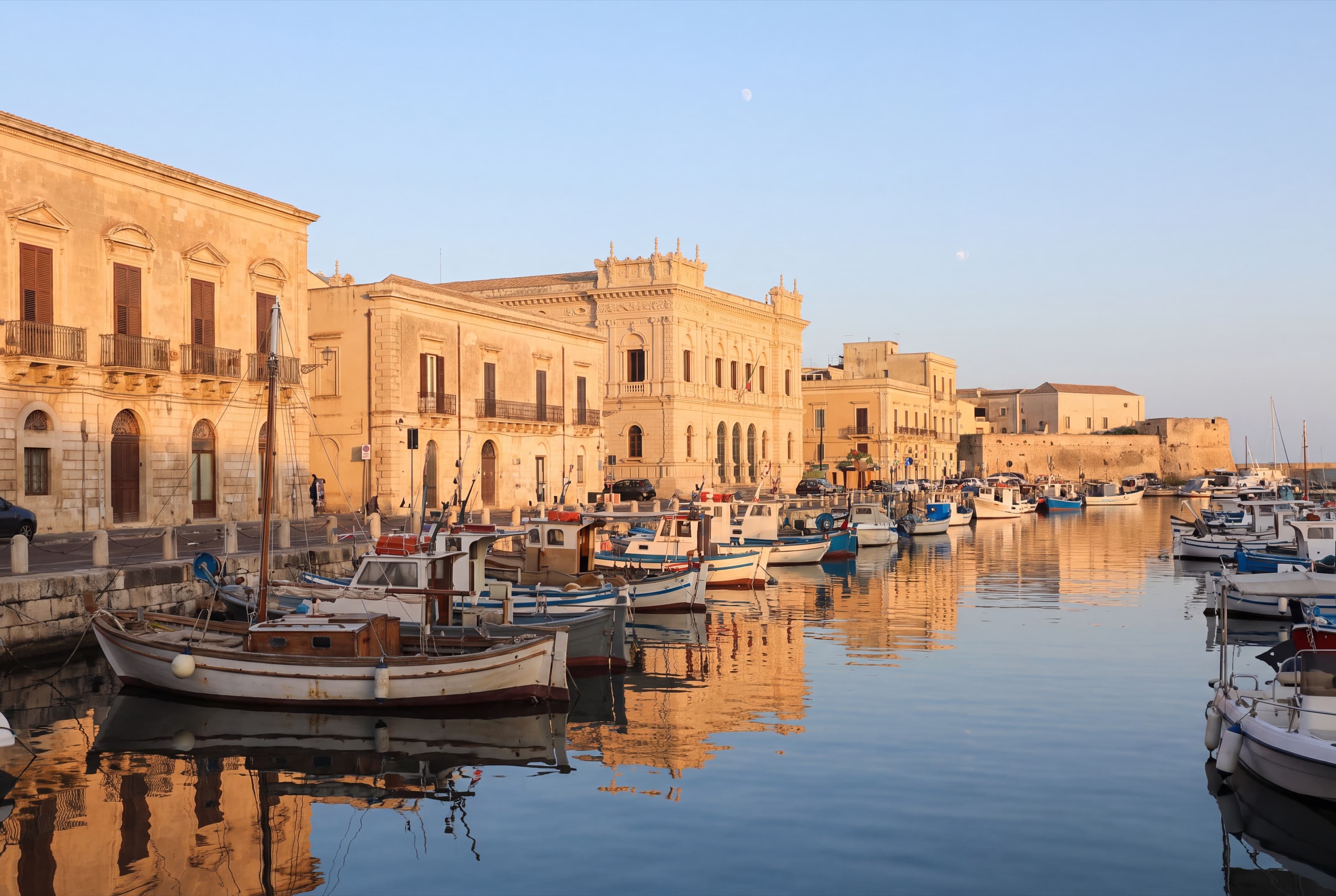 Barche da pesca e piccole barche ormeggiate nel porto di Ortigia nella luce del mattino