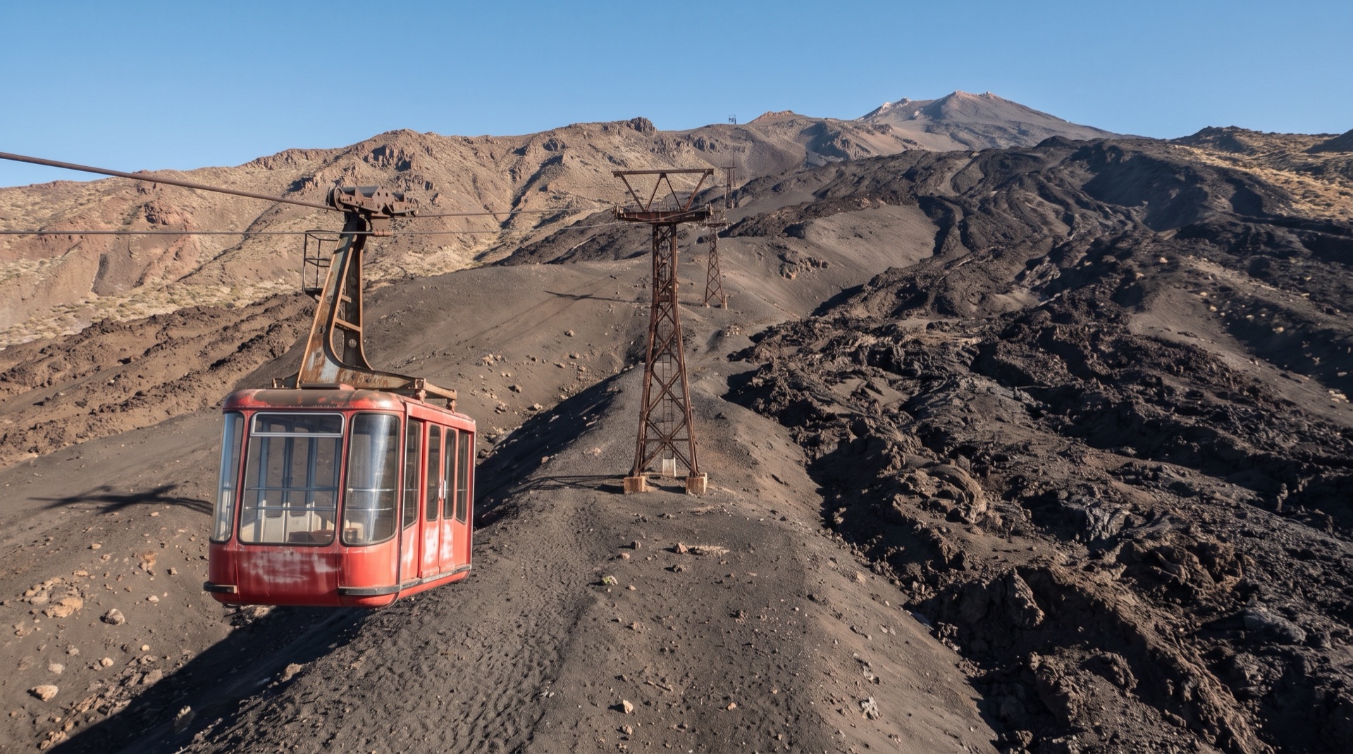 Walkers in helmets and mountain jackets on a marked route across ash and lapilli above 2,500 metres on Mount Etna