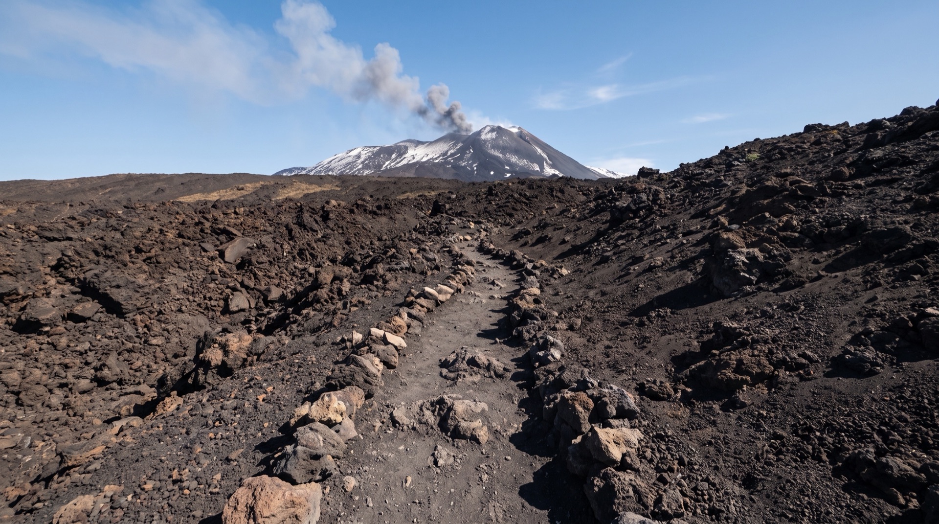 Funivia dell'Etna cabins climbing the black slope above the Rifugio Sapienza base station on the southern flank of Mount Etna