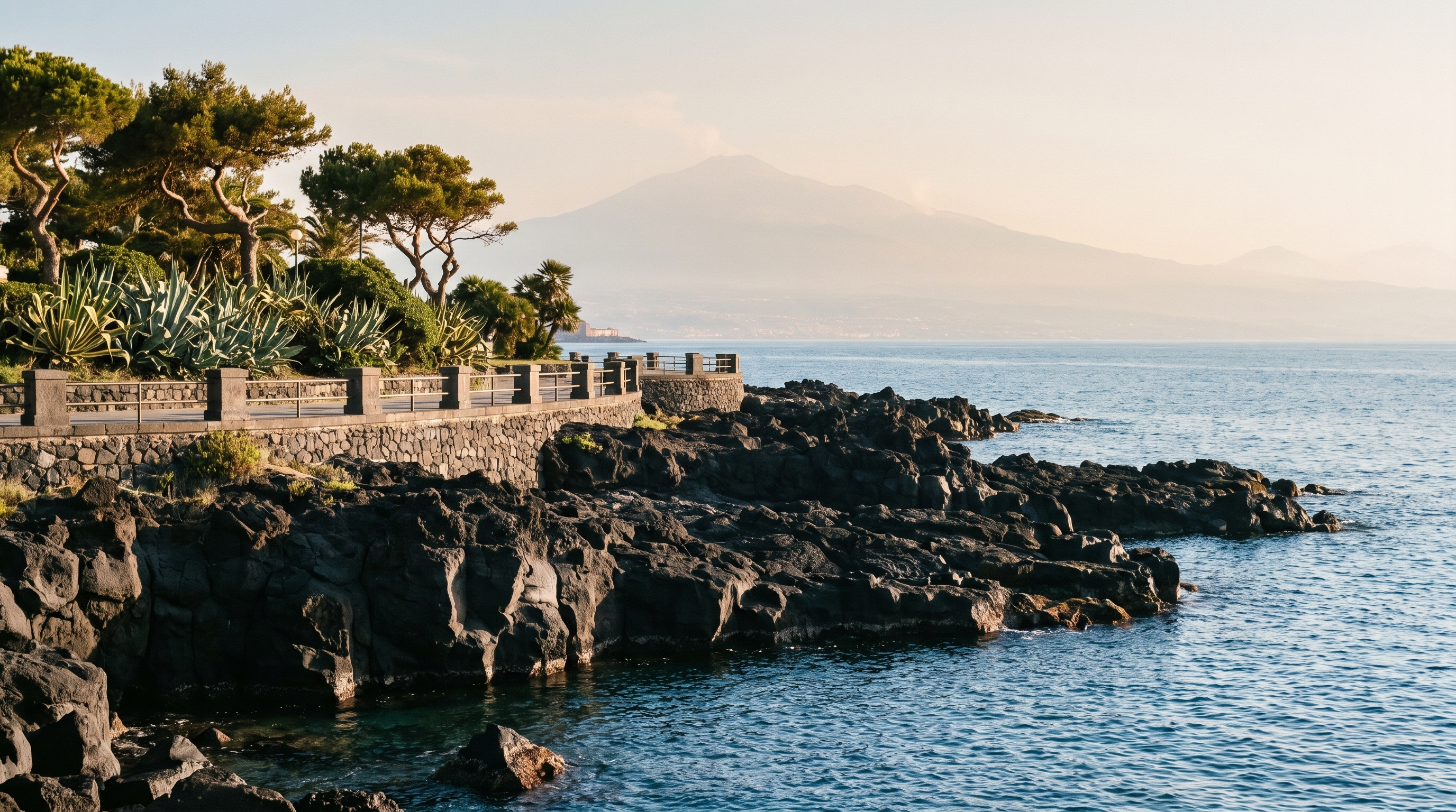 The Catania seafront, black lava rock shelves dropping into the water below the promenade