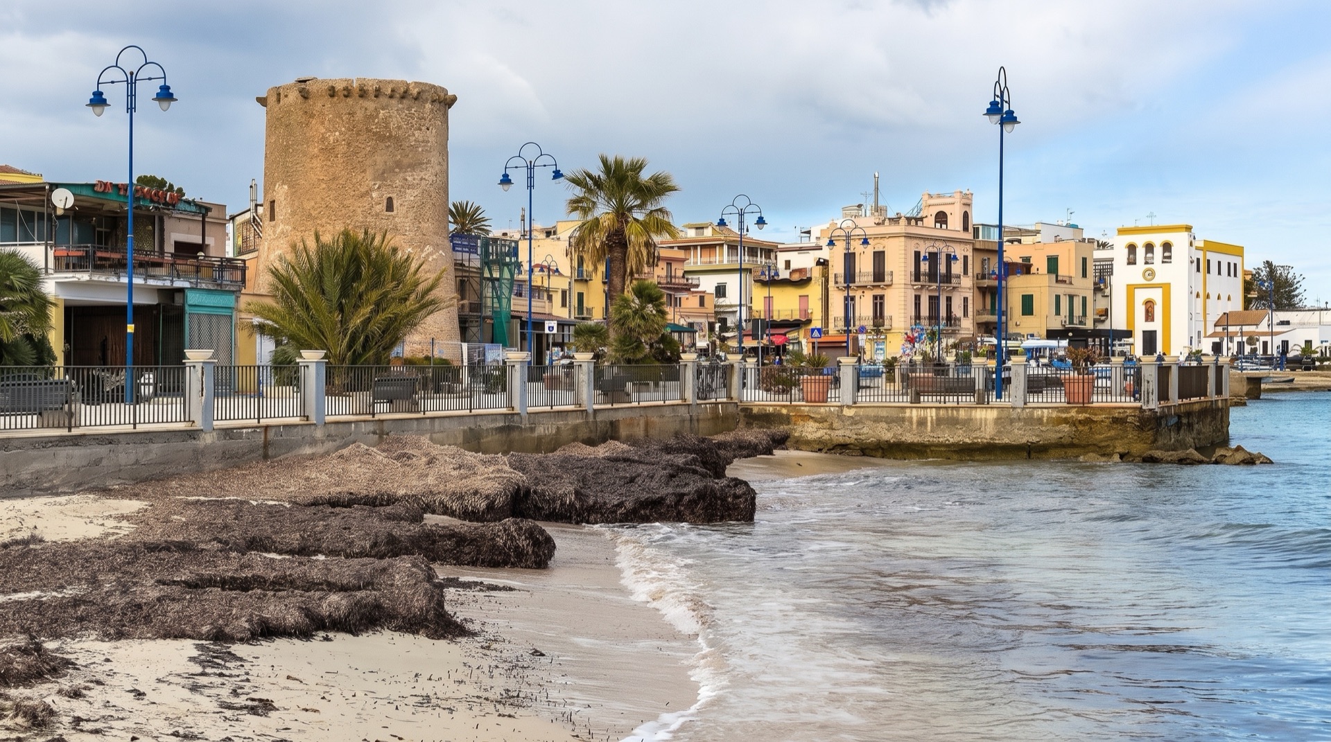 The Mondello seafront along viale Regina Elena, pedestrianised for the summer season, with palms and walkers in the late afternoon light.