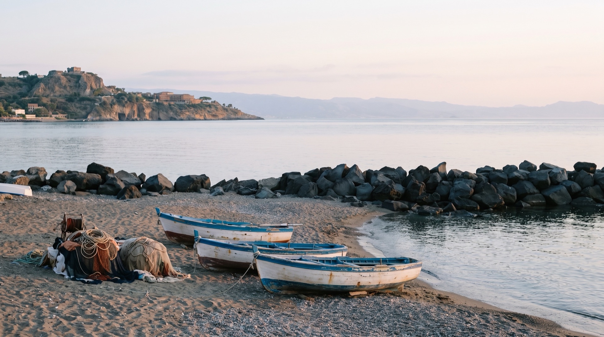 Small fishing boats drawn up on the shore at Giardini Naxos harbour