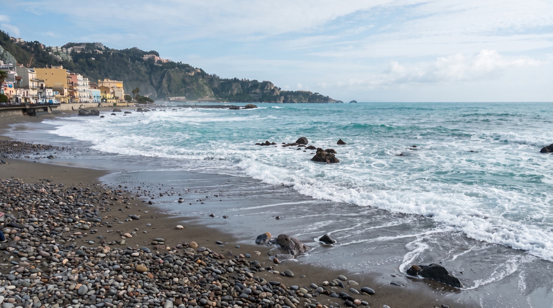 Pebble beach at Giardini Naxos with clear shallow water, a short walk from the seafront hotels