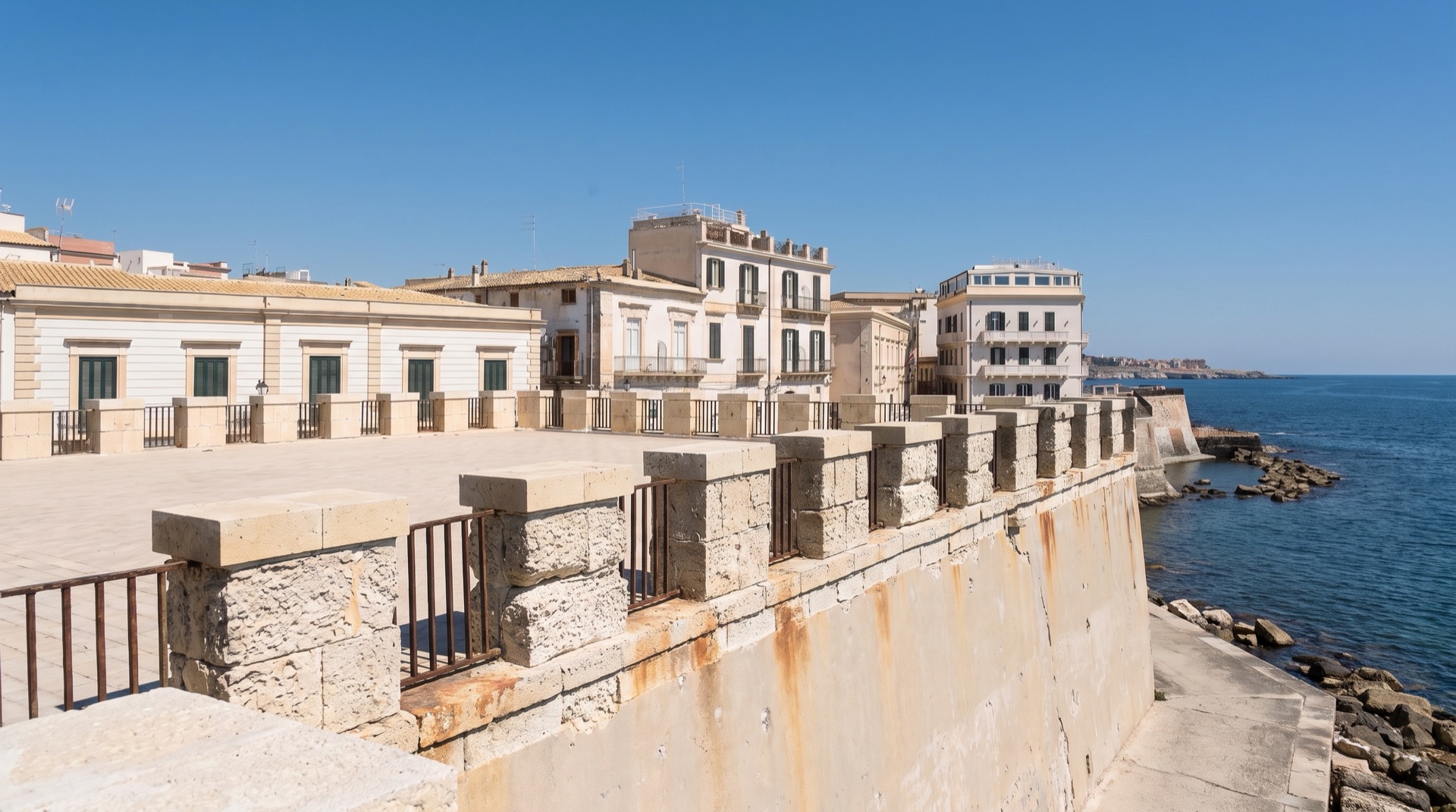 Waves breaking against the sea wall along the Ortigia waterfront in Siracusa